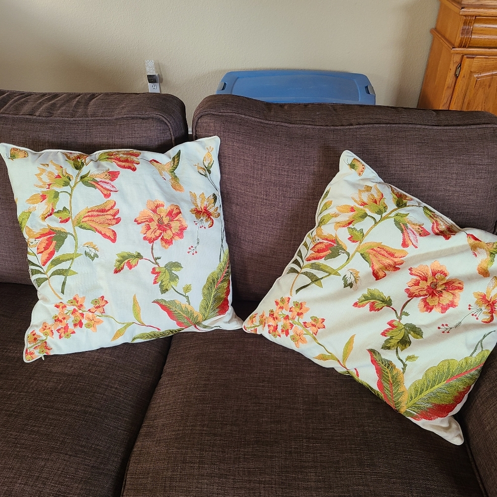 2 pillows with embroidered flowers and hummingbirds